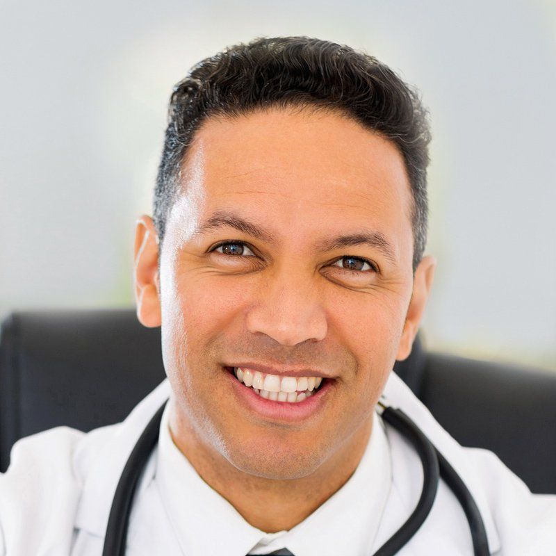 A smiling doctor with a stethoscope around his neck