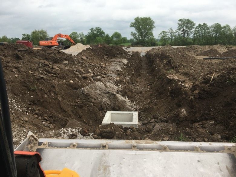 An excavator is digging a hole in the dirt