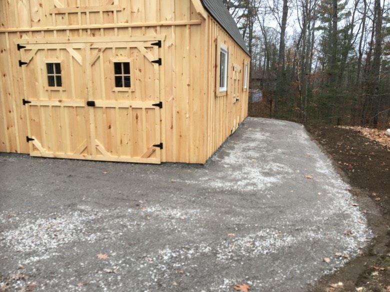A wooden building with a driveway in front of it