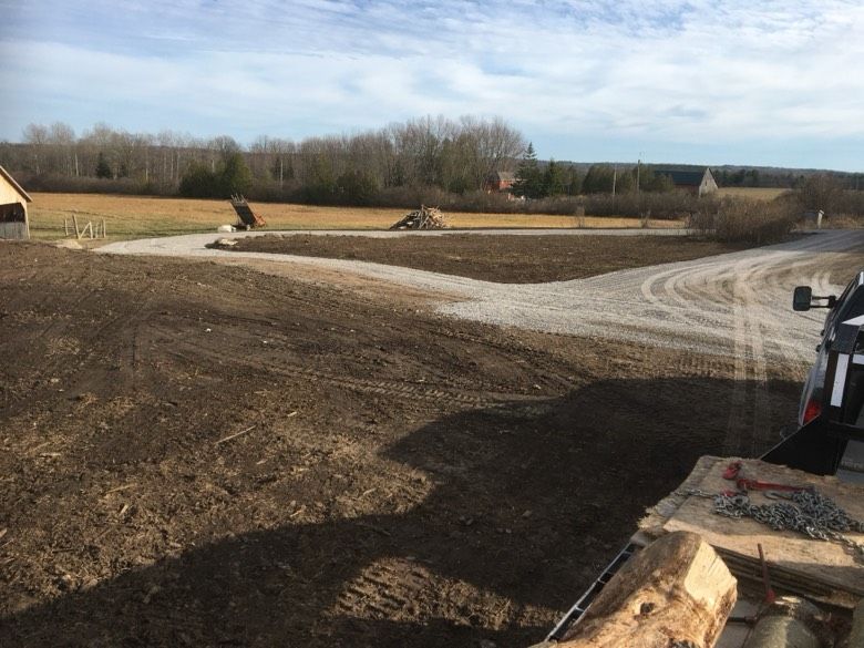 A truck is parked on the side of a dirt road