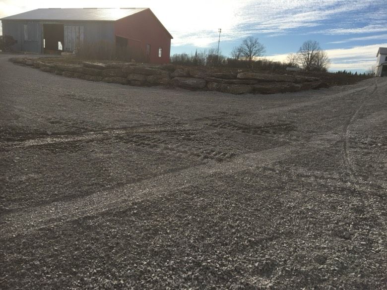 A road with a red barn in the background