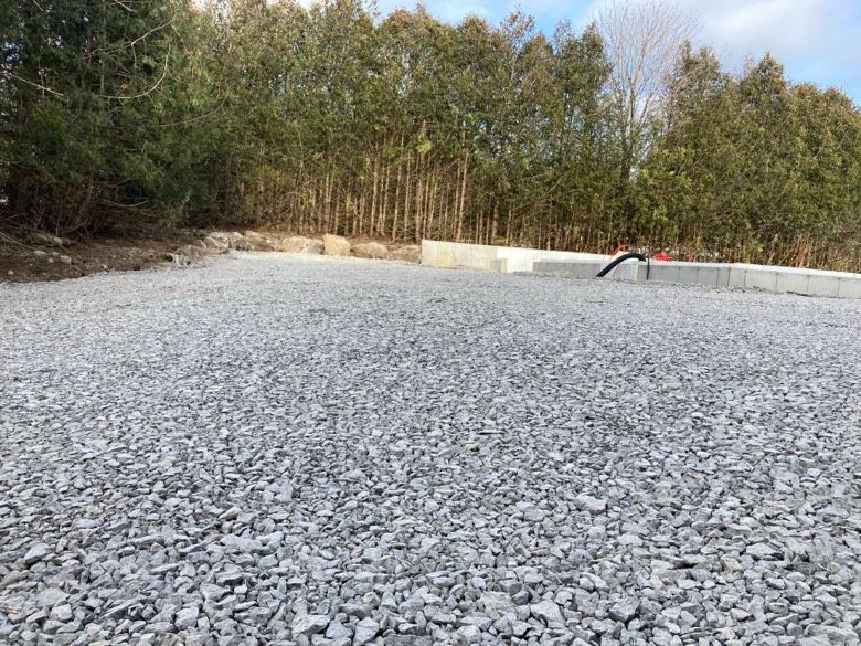 A pile of gravel is sitting in the middle of a forest.