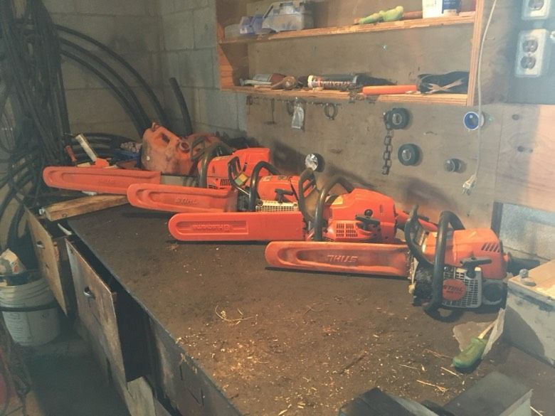 A bunch of chainsaws are sitting on a table
