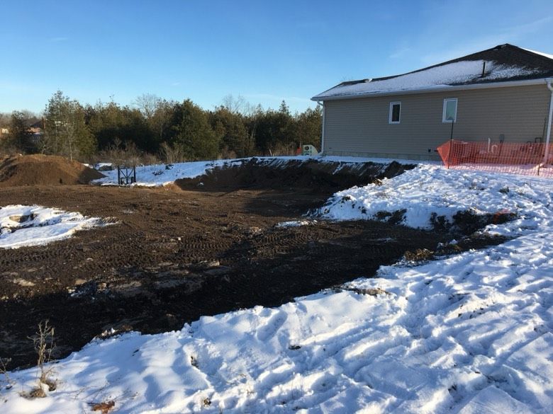 A house is sitting on top of a snow covered field.