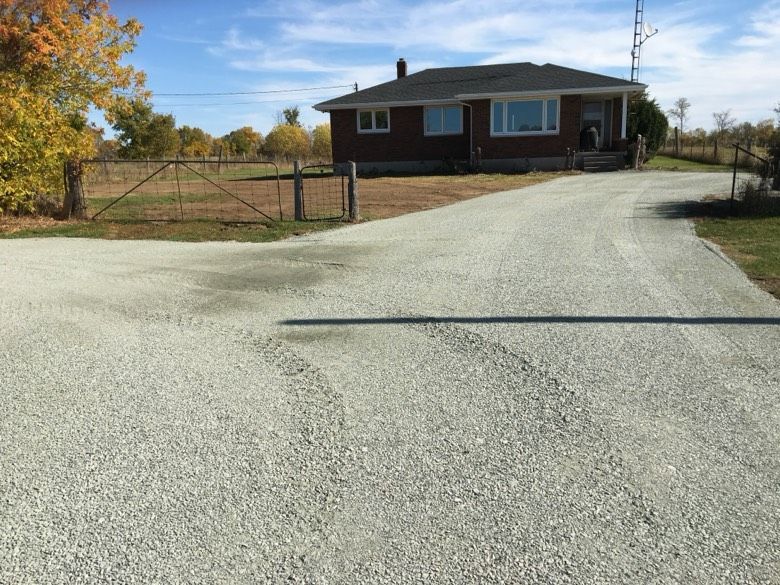 A house with a gravel driveway leading to it