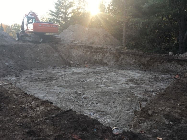 A large excavator is digging a hole in the dirt.