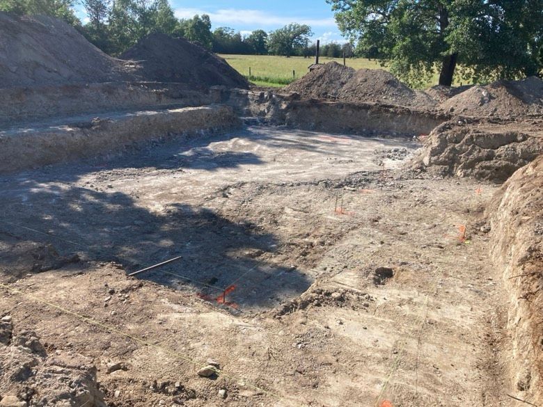 A large pile of dirt is sitting in the middle of a dirt field.