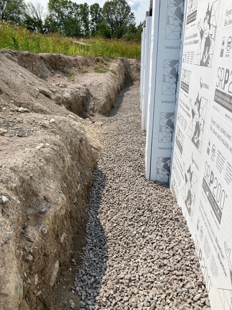 A drainage system is being installed on the side of a building.