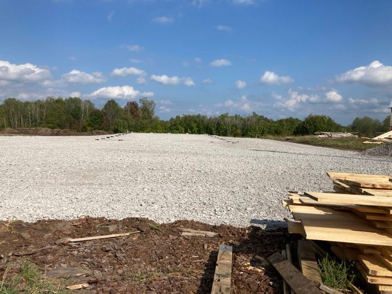 A pile of wood is sitting in the middle of a gravel field.