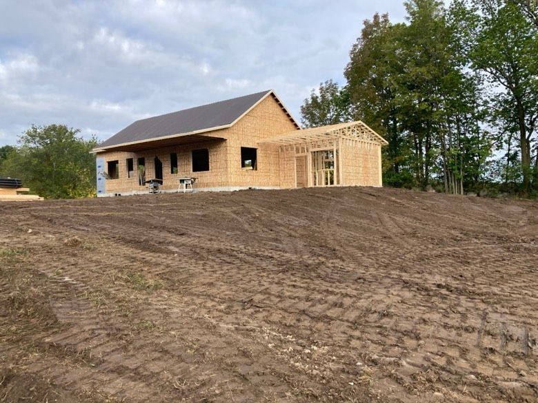 A house is being built in the middle of a dirt field.