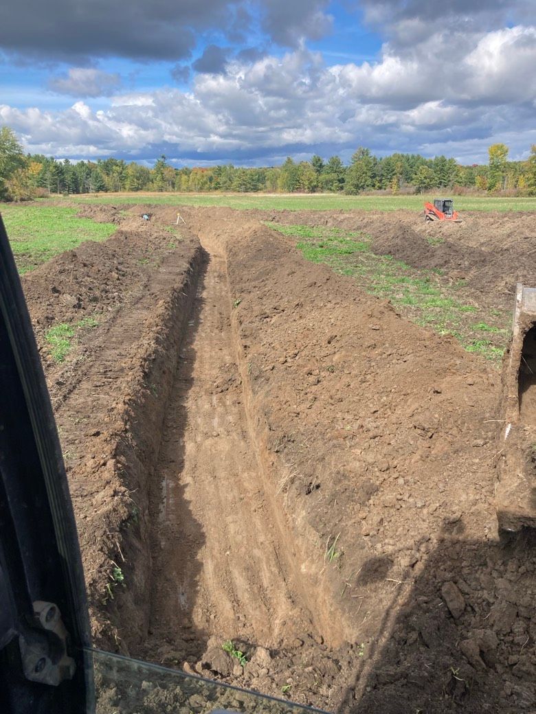A person is driving a bulldozer through a dirt field.