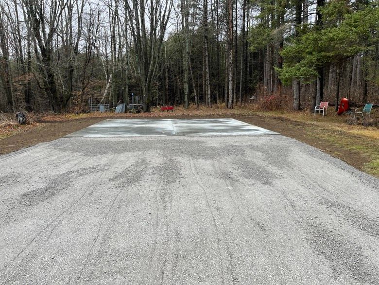 A gravel road in the middle of a forest with trees in the background.