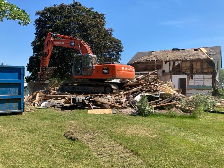A large excavator is demolishing a house.