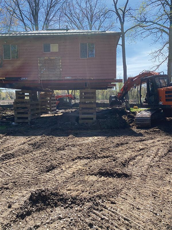 A house is being moved to a new location on stilts.