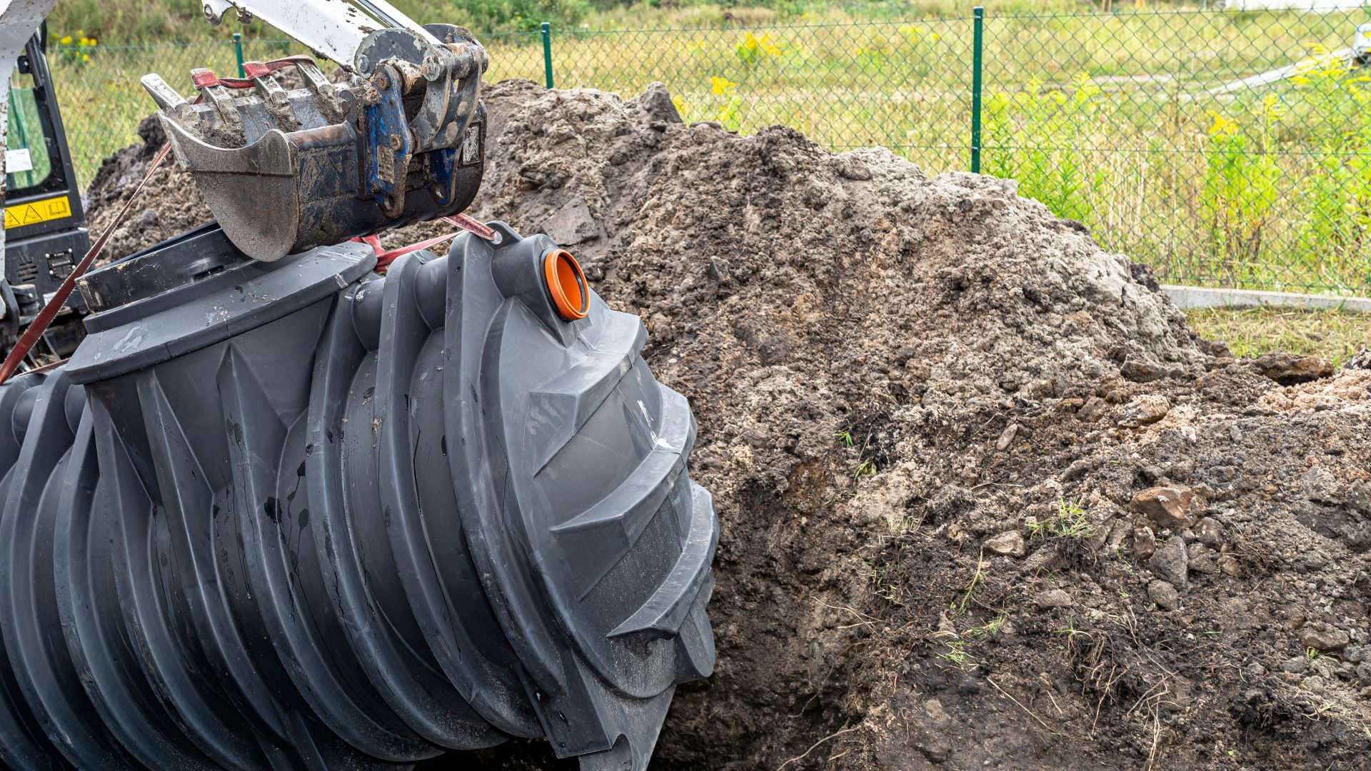 A tractor is digging a hole for a septic tank.