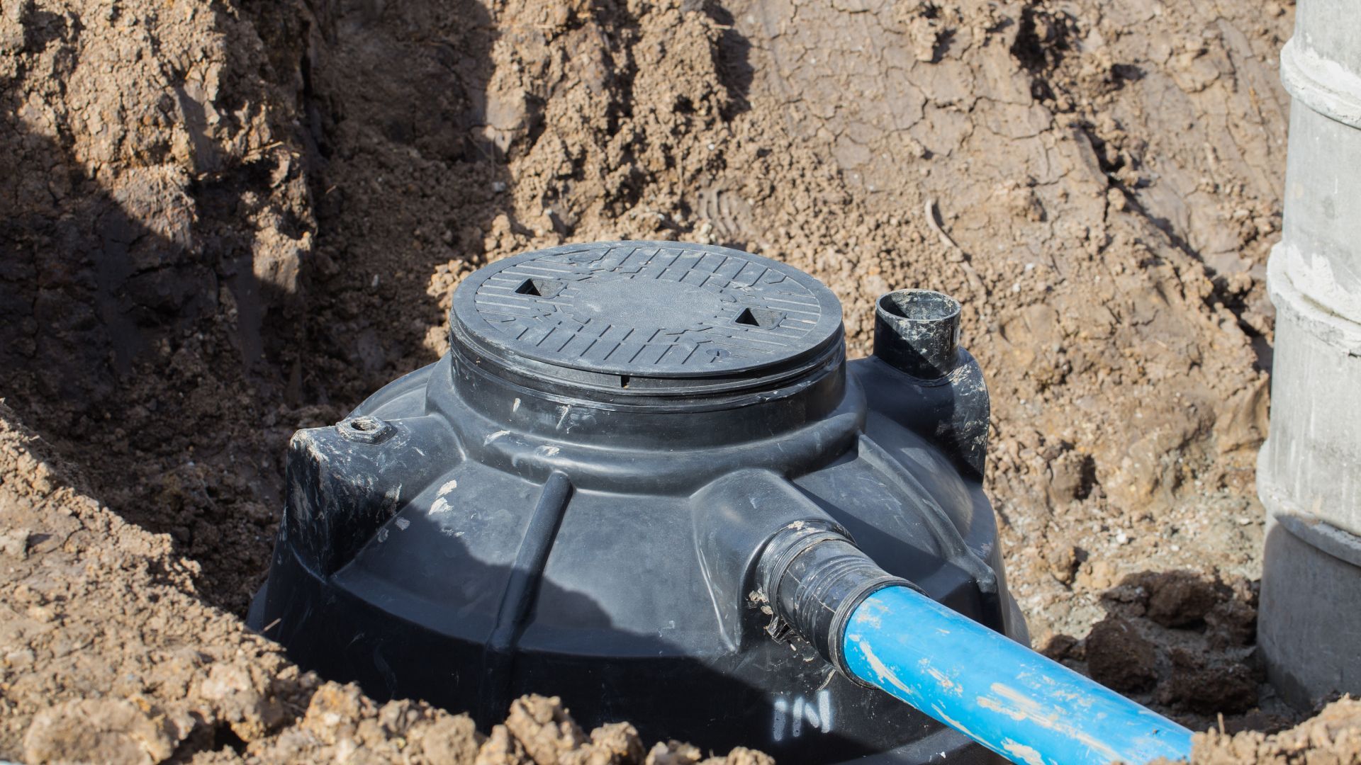 A septic tank is being installed in a hole in the ground.