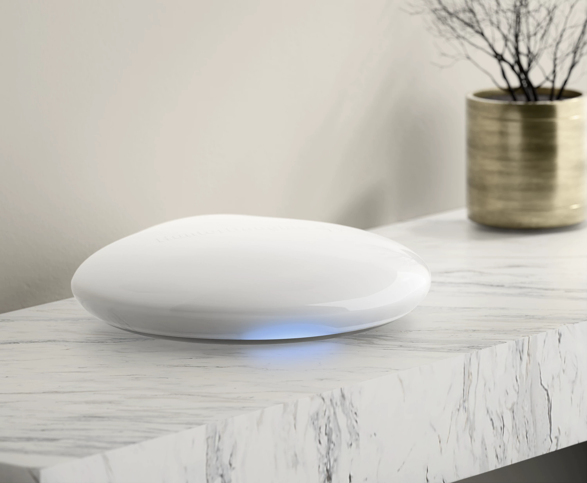 A white object is sitting on top of a marble table next to a potted plant.