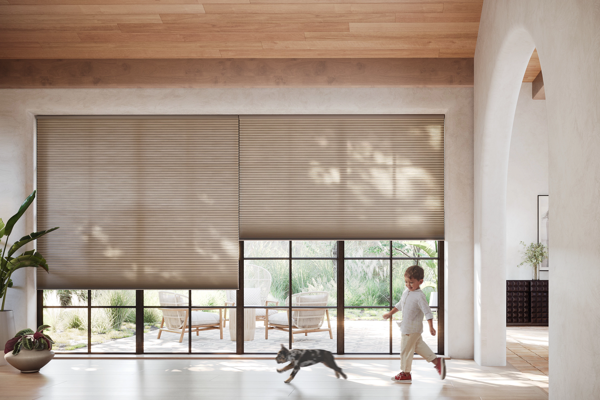 A little boy is walking a dog in a living room.