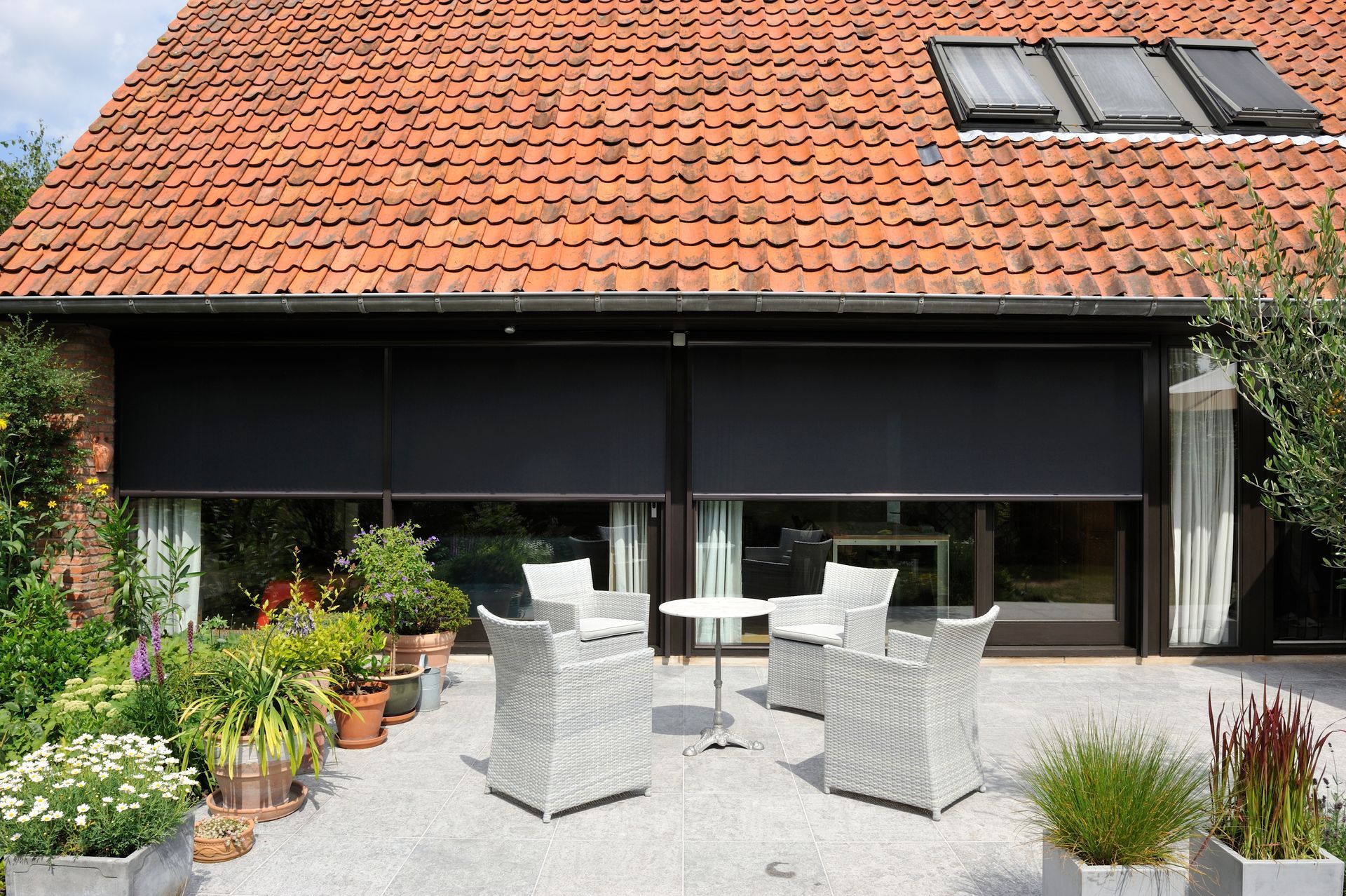 A living room with a couch wicker chairs and a coffee table