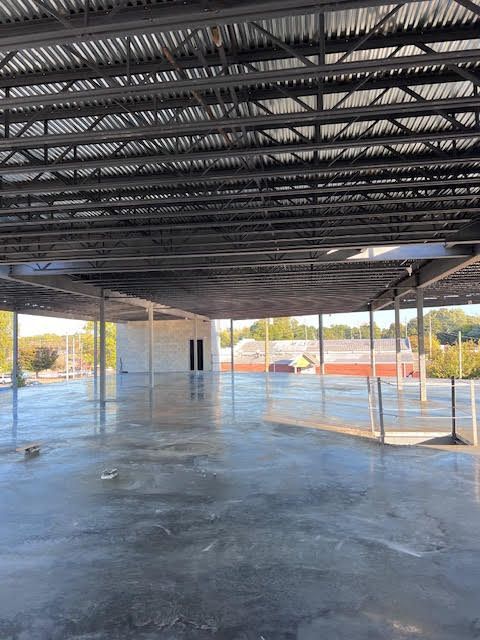 A large empty room with a metal roof and a concrete floor.
