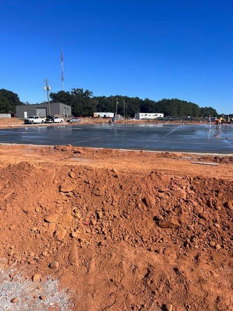 A construction site with a lot of dirt and a blue sky in the background.