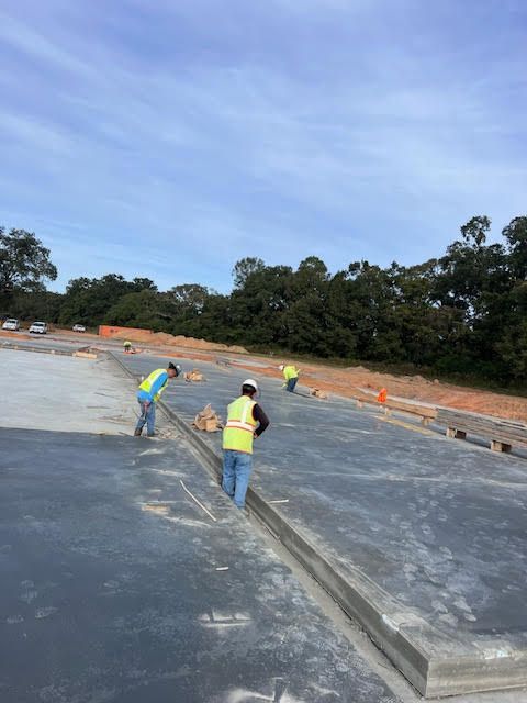 A group of construction workers are working on a concrete floor.