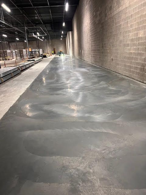 A large warehouse with a concrete floor and brick walls.