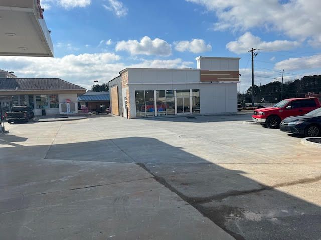 A gas station with a lot of cars parked in front of it.