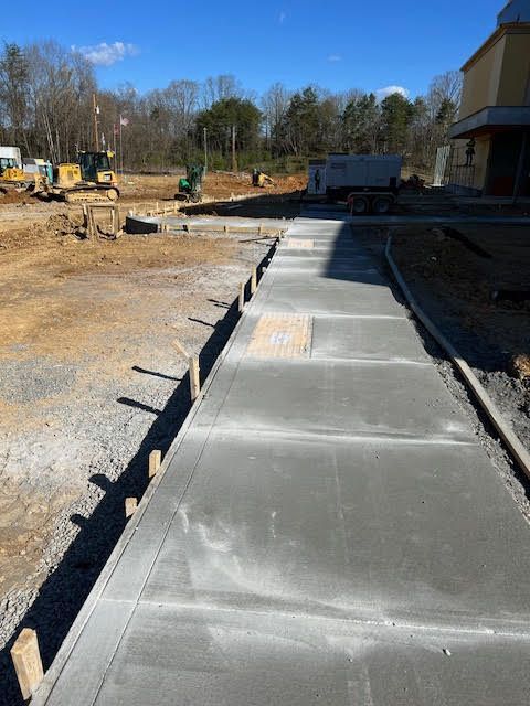 A concrete walkway is being built in a construction site