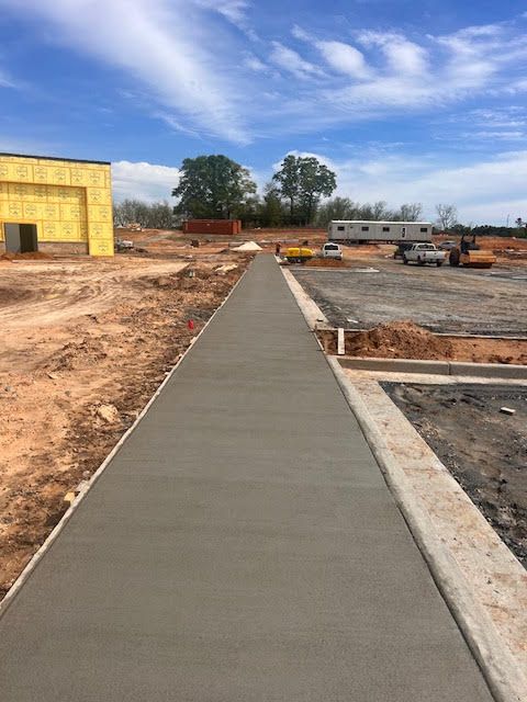 A concrete walkway leading to a building under construction.