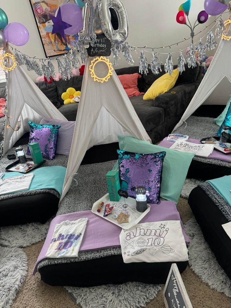 A group of people are sitting under tents in a living room.