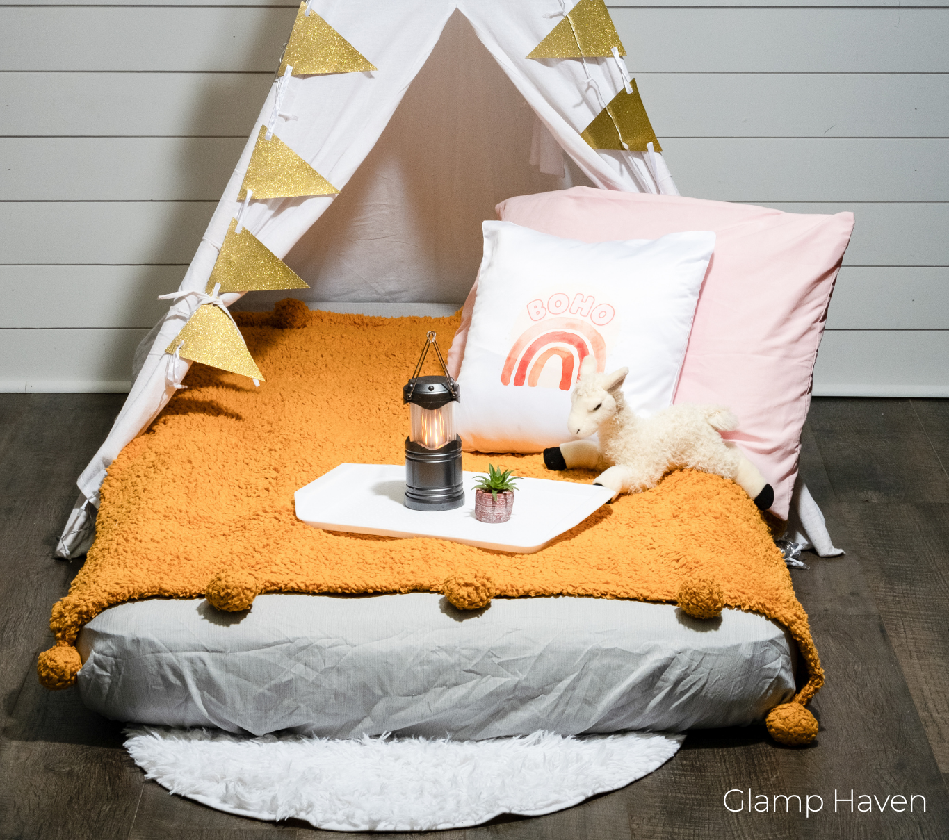 A bed with a teepee and pillows on it