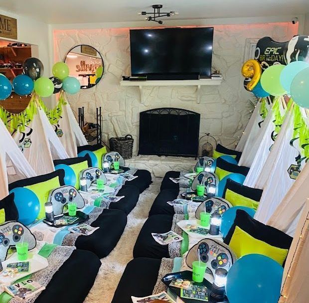 A room decorated for a party with balloons and a tv