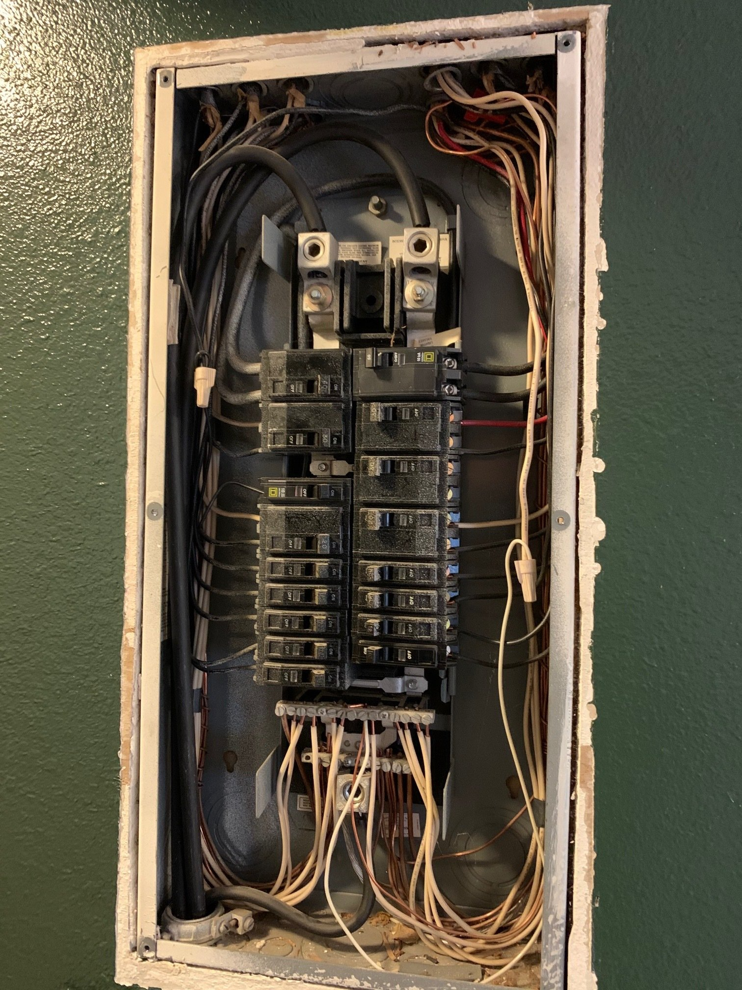 A dirty electrical box with a lot of wires coming out of it.