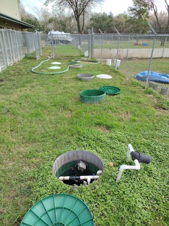 A septic tank is sitting in the middle of a lush green field.