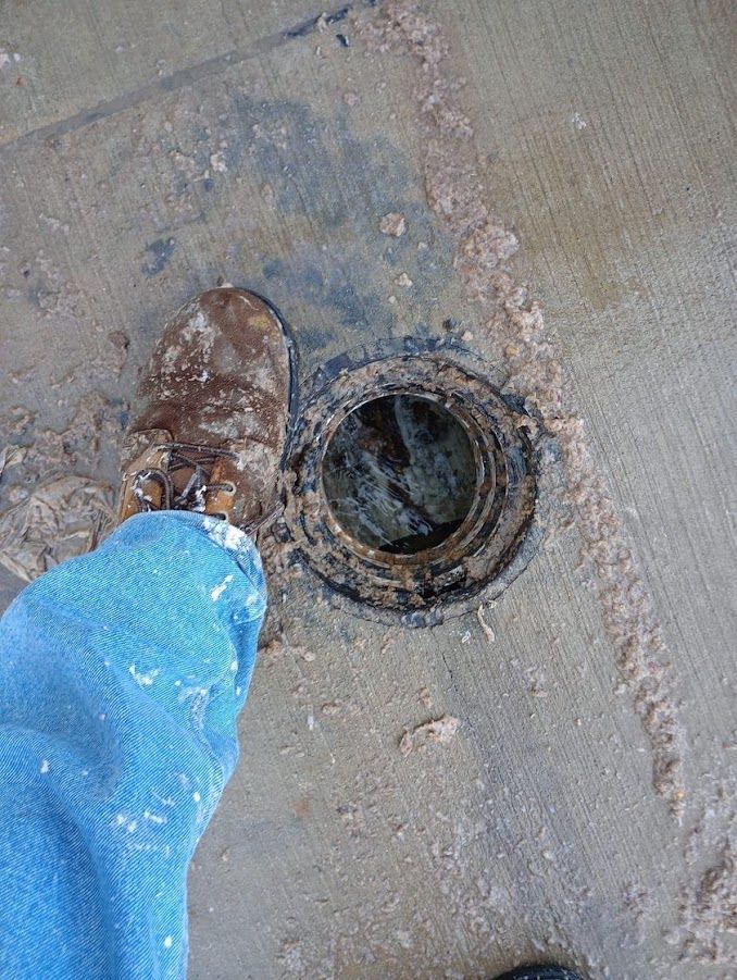 A person is standing next to a hole in the ground.