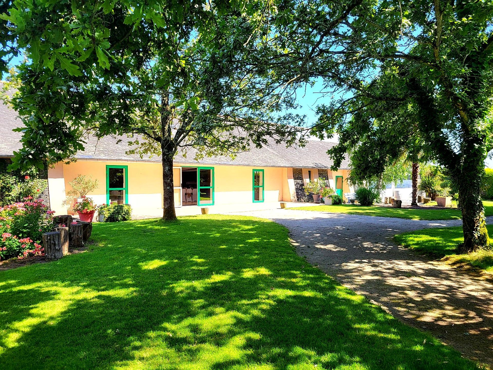 Une maison avec beaucoup d'herbe et d'arbres devant elle