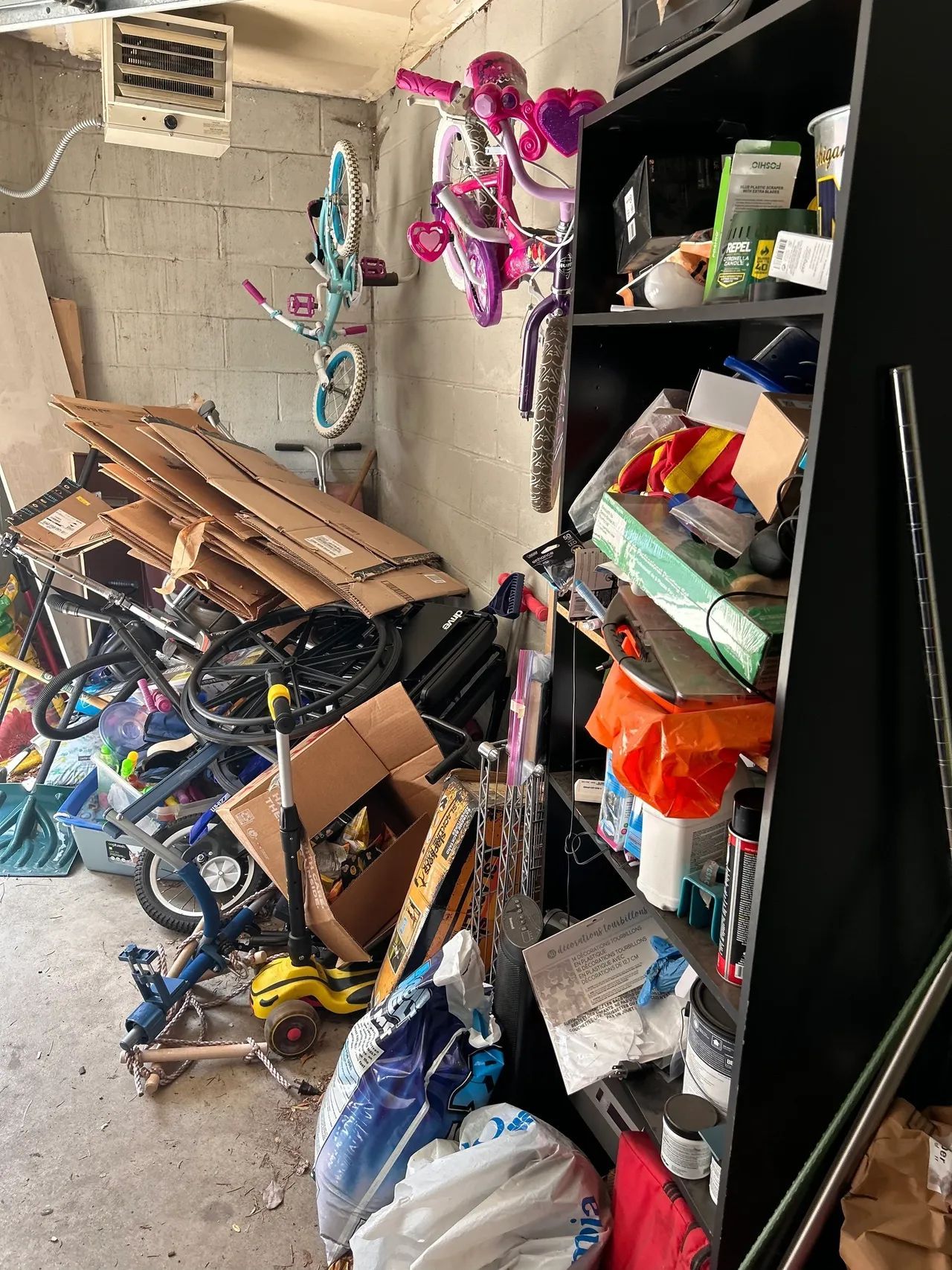 A garage filled with lots of junk and bicycles.
