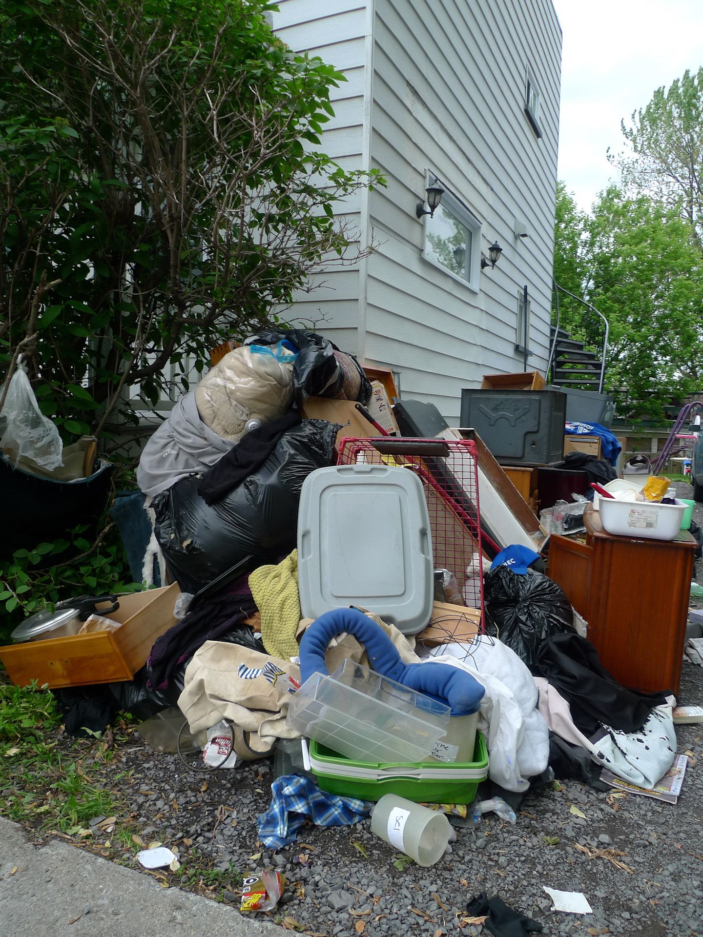 A pile of trash is sitting in front of a house.