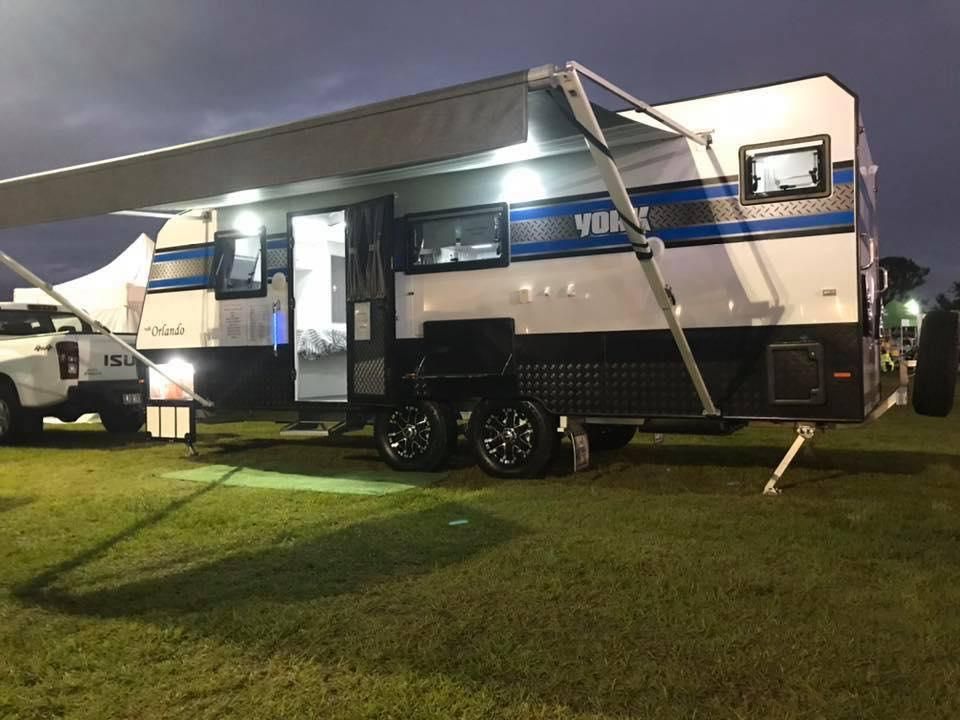 A Camper Trailer is Parked in a Grassy Field at Night — J & D Caravans In Tamaree, QLD
