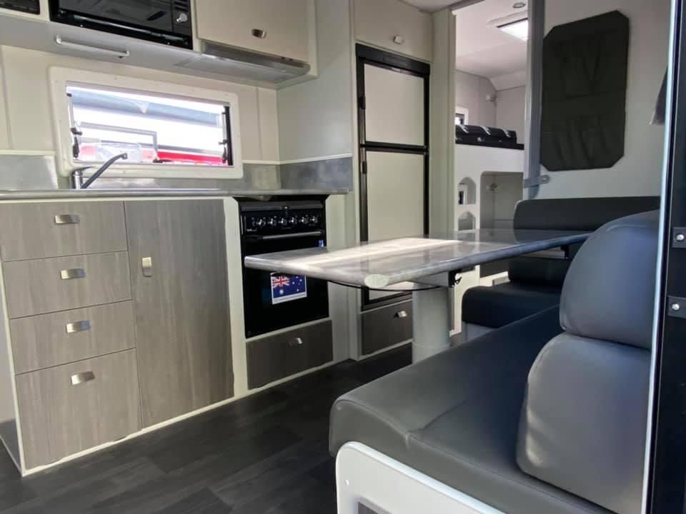 A Kitchen in a Camper With a Table and Chairs — J & D Caravans In Glenwood, QLD