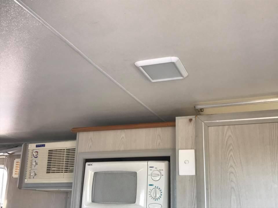 A Kitchen With a Microwave and a Ceiling Fan — J & D Caravans In Tamaree, QLD