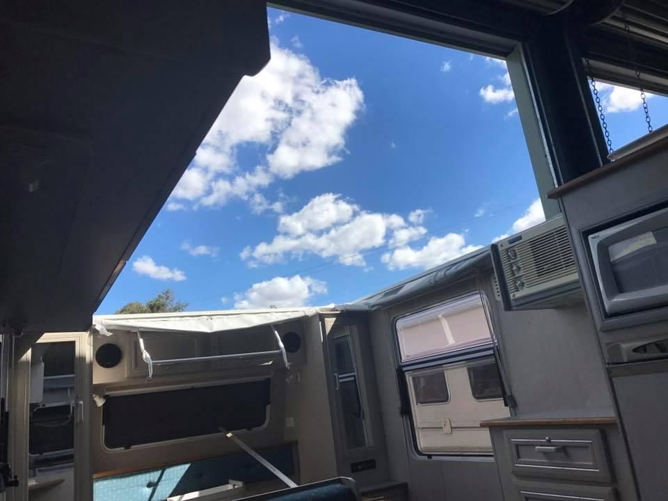 A Kitchen With a Blue Sky and Clouds Behind the Window — J & D Caravans In Tin Can Bay, QLD