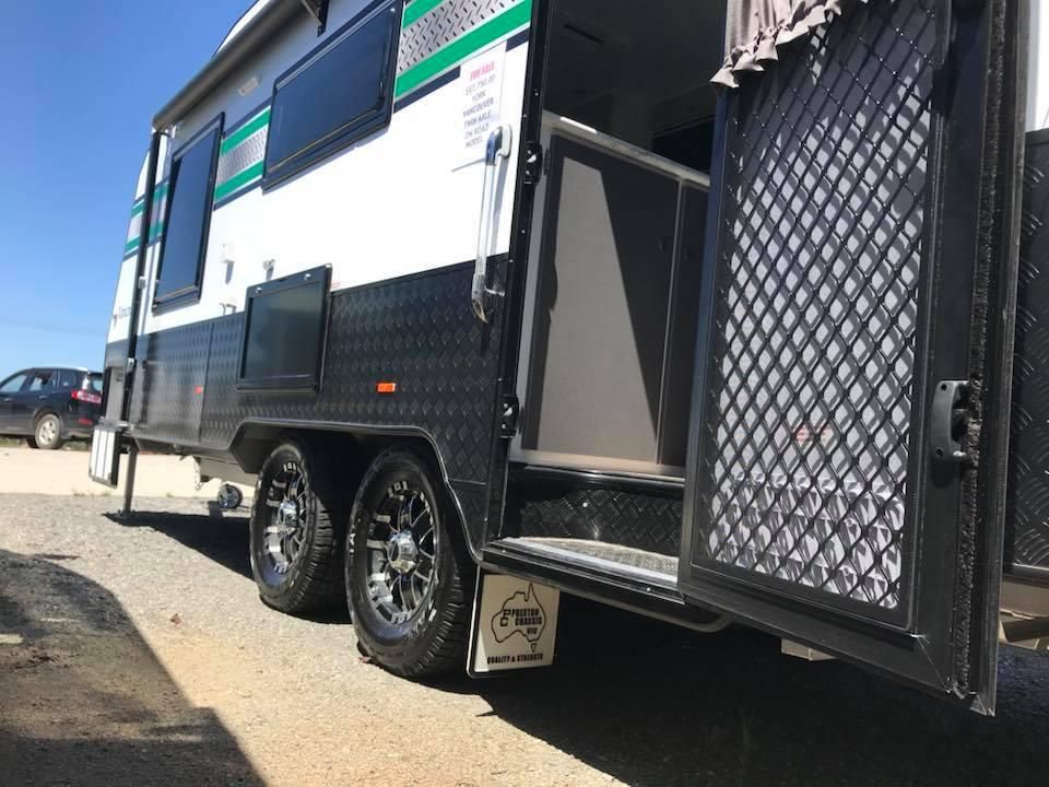 A White and Black Trailer With the Door Open is Parked on the Side of the Road — J & D Caravans In Tamaree, QLD