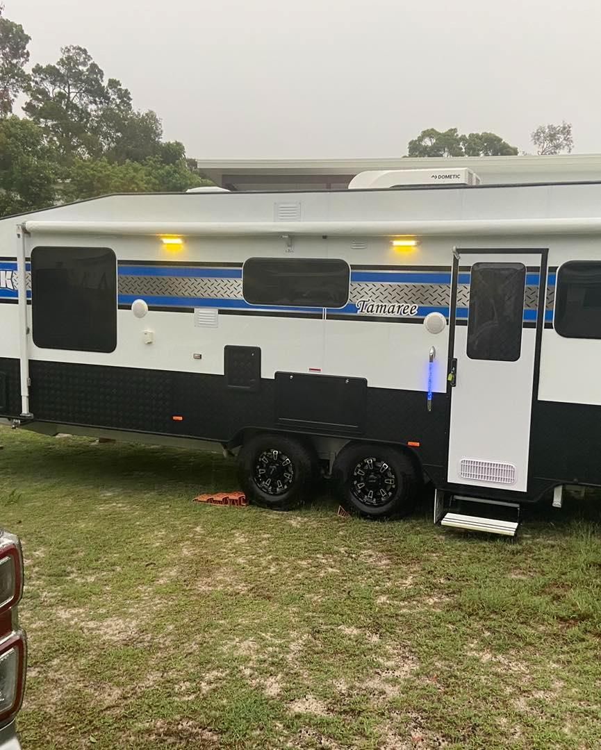 A White and Black Trailer is Parked in a Grassy Field — J & D Caravans In Tamaree, QLD