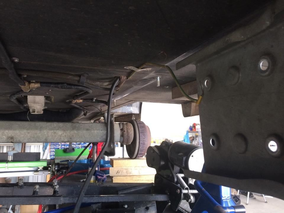 A Car is Sitting on a Lift in a Garage — J & D Caravans In Cooroy, QLD