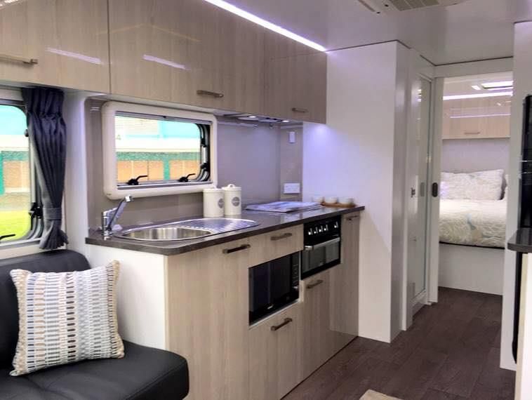 A Kitchen in a Camper With a Couch and a Sink — J & D Caravans In Tin Can Bay, QLD