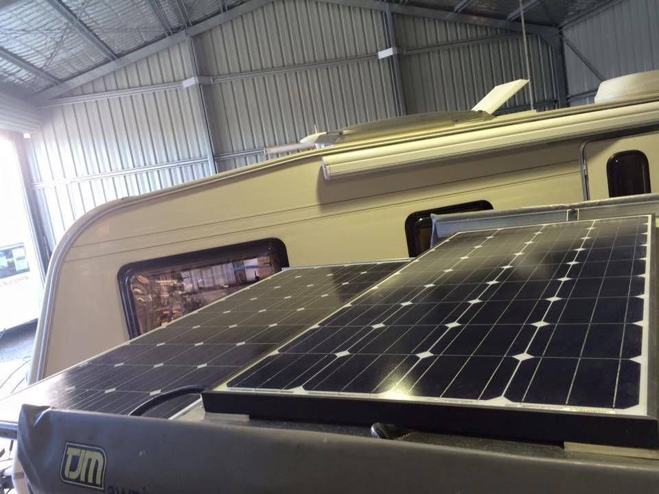 Two Solar Panels Are Sittingon Top of a Camper in a Garage — J & D Caravans In Tamaree, QLD