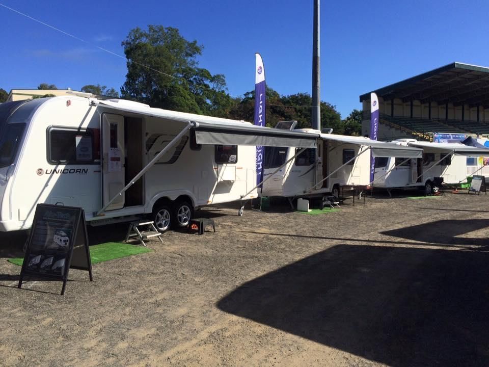 A Row of White Rvs Are Parked in a Dirt Lot — J & D Caravans In Glenwood, QLD