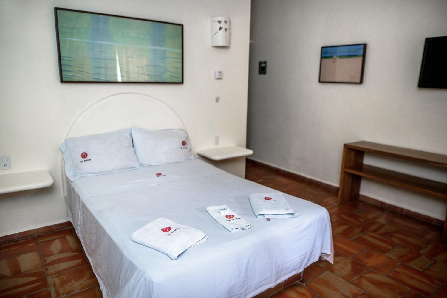 A bedroom with a bed and a painting on the wall.